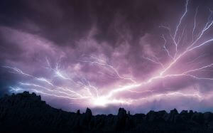 Lightning in the sky above trees.