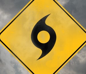 Hurricane symbol on a yellow caution sign with a stormy sky in the background.